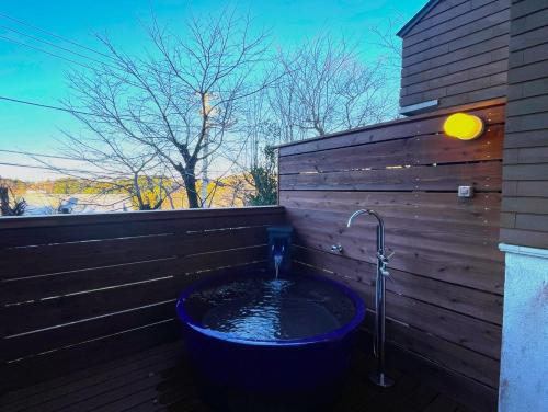 a bath tub with a water faucet in a wooden wall at Atami Venus in Atami