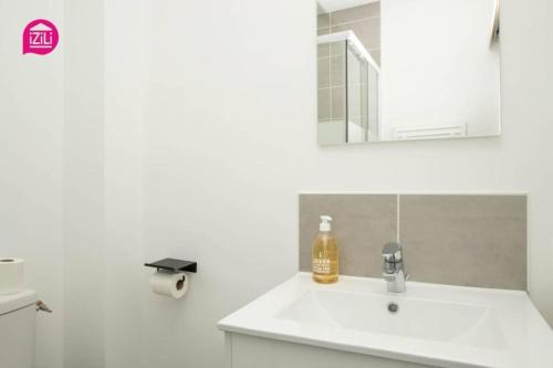 une salle de bain blanche avec un lavabo et un miroir dans l'établissement Huka Studio - Centre Ville Poitiers, à Poitiers