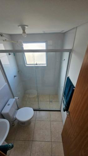 a bathroom with a toilet and a glass shower at Bem-vindo ao seu refúgio em Palhoça in Palhoça
