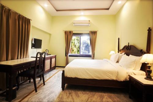 a bedroom with a bed and a desk and a computer at CABANA- 5 BHK Luxury Villa near Udaipur in Dabok