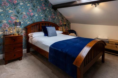 a bedroom with a large bed with a blue blanket at The Royal Station Hotel in Carnforth