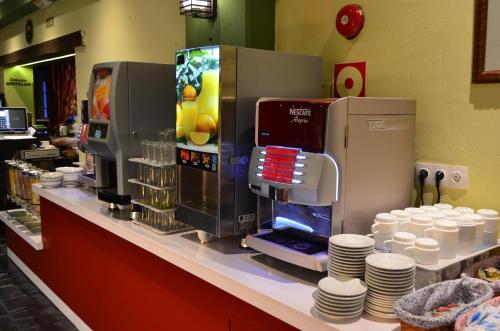 a coffee shop counter with a coffee making machine at Hotel GHM Monachil in Sierra Nevada