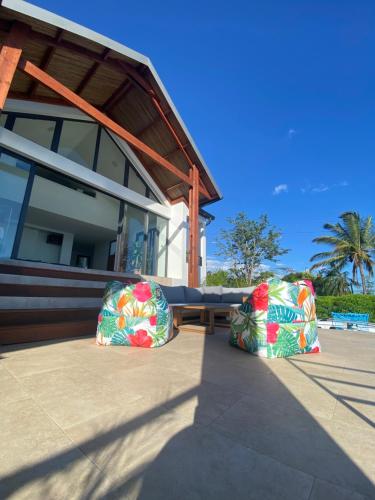 two pillows sitting on a patio in front of a house at Villa Ocean neuve piscine double et vue mer proche du centre ville in Les Avirons