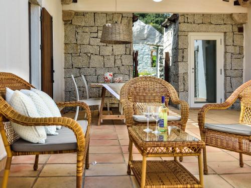 a patio with wicker chairs and a table at Li Conchi 13 in Cala Sinzias