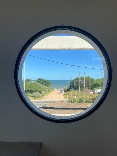 a round window with a view of a road at SANTAMARIADELMAR Casa a estrenar frente al mar in Manantiales
