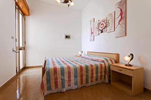 a bedroom with a bed and a table with a lamp at Helle Wohnung In Santa Maria Al Bagno in Santa Maria al Bagno