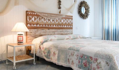 a bedroom with a bed and a table with a lamp at Li Conchi 13 in Cala Sinzias