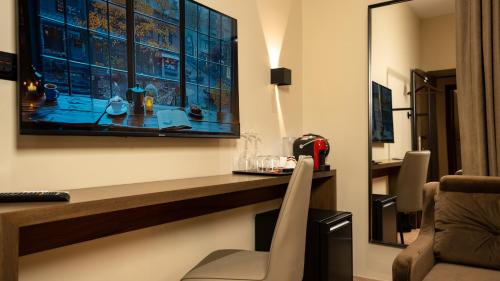 a room with a desk and a television on the wall at CLOUD 5 Blloku Rooms Tirana in Tirana