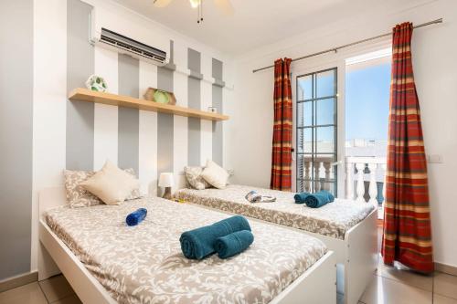 カジャオ・サルバヘにあるVilla Naranja Mit Beheiztem Pool Und Meerblickのバルコニー付きの客室内のベッド2台
