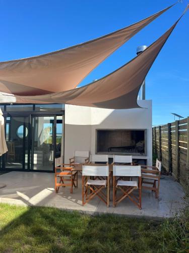 a patio with a table and chairs under a canopy at SANTAMARIADELMAR Casa a estrenar frente al mar in Manantiales