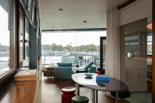 a living room with a table and a view of a marina at SWEETS - Oosterdoksdraaibrug in Amsterdam