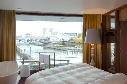 a bedroom with a large window with a view of a bridge at SWEETS - Oosterdoksdraaibrug in Amsterdam