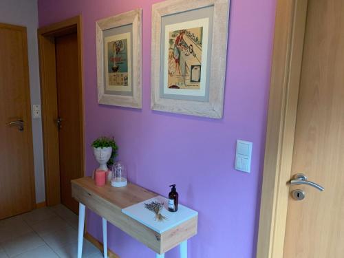 a room with a table and a purple wall at Fewo 5 Jahreszeiten in Bell