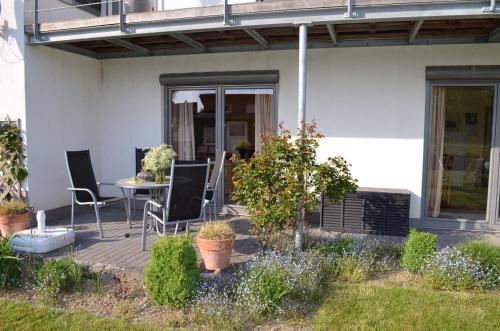 a patio with chairs and a table in front of a house at Fewo 5 Jahreszeiten in Bell
