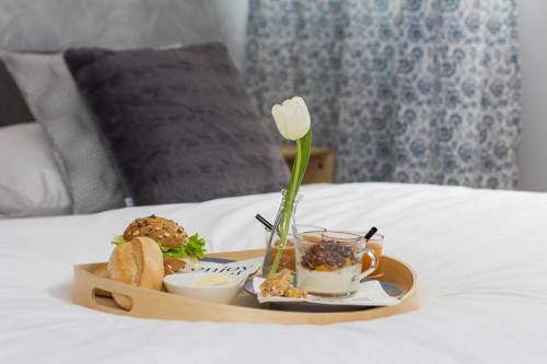 スプリトにあるB&B Vibeのベッドの上に食べ物とコーヒーのトレイ