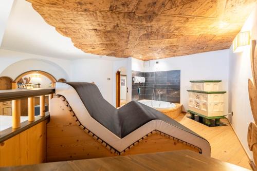 a large bathroom with a wooden ceiling and a tub at Croce Bianca Leisure & Spa Hotel in Canazei