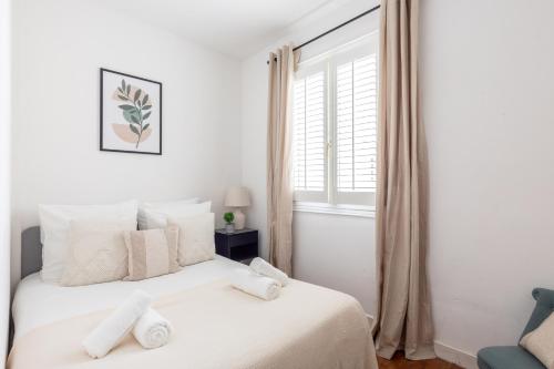 une chambre avec un lit blanc avec des oreillers blancs dans l'établissement Appartement Prestige dans le 16ᵉ, à Paris