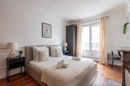 une chambre avec un lit avec deux ours en peluche dessus dans l'établissement Appartement Prestige dans le 16ᵉ, à Paris
