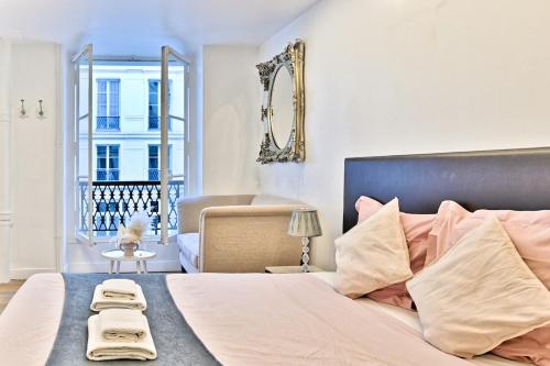 une chambre avec un grand lit et une fenêtre dans l'établissement Pleasant Apartment Close to Galerie Lafayette - II, à Paris