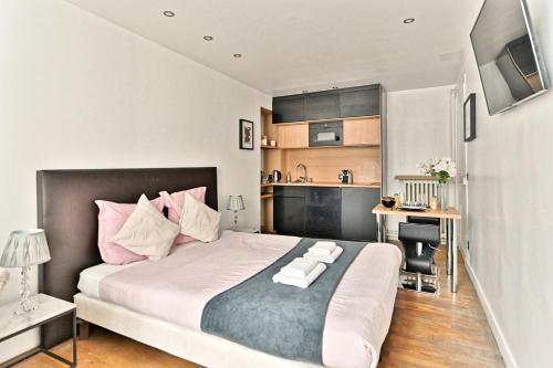 une chambre avec un grand lit avec des oreillers roses dans l'établissement Pleasant Apartment Close to Galerie Lafayette - II, à Paris