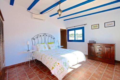 a bedroom with a bed and a nightstand and blue ceilings at Villa Mediterraneo Rooms Piscina jardin parking in Blanes