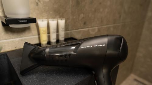 a black blow dryer sitting on top of a counter at CLOUD 5 Blloku Rooms Tirana in Tirana