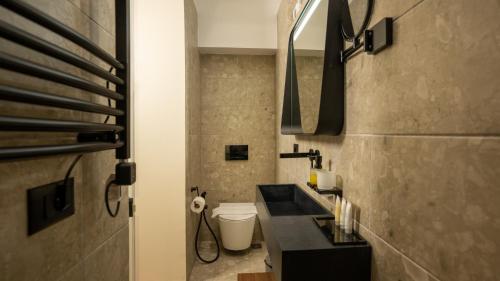 a bathroom with a black sink and a toilet at CLOUD 5 Blloku Rooms Tirana in Tirana