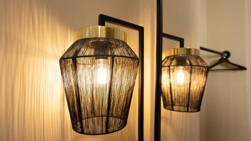two lights on a wall next to a mirror at CLOUD 5 Blloku Rooms Tirana in Tirana