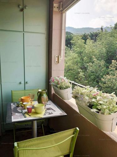 d'une table et de chaises sur un balcon orné de plantes. dans l'établissement 3PA45 - Très confortable T2 avec terrasses dans résidence avec piscine et parking, à Collioure
