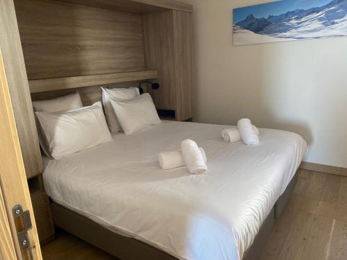 une chambre avec un lit avec deux serviettes dessus dans l'établissement Appartement Haute gamme ski aux pieds, piscine, sauna., à Bourg-Saint-Maurice