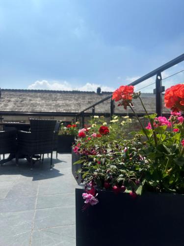 a balcony with flowers and a piano on a patio at The Royal Station Hotel in Carnforth