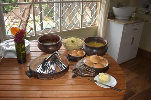 a table with bowls and plates of food on it at Kili Kivuli in Msaranga