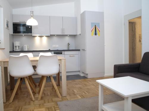 a kitchen and living room with a table and chairs at Haus Residenz Wohnung 18 in Norderney