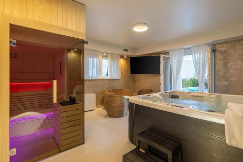 un bagno con una grande vasca e una grande finestra di Seaside Luxury Villa Castello Rogoznica Heated Pool, Sauna, Gym & Jacuzzi a Rogoznica (Rogosnizza)