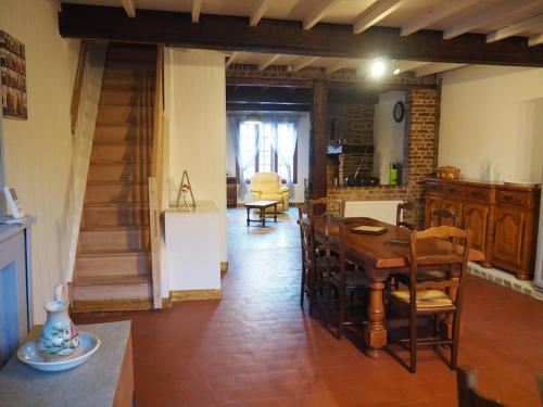 une salle à manger avec une table et des chaises et un escalier dans l'établissement La Crémaillère, à Les Mazures