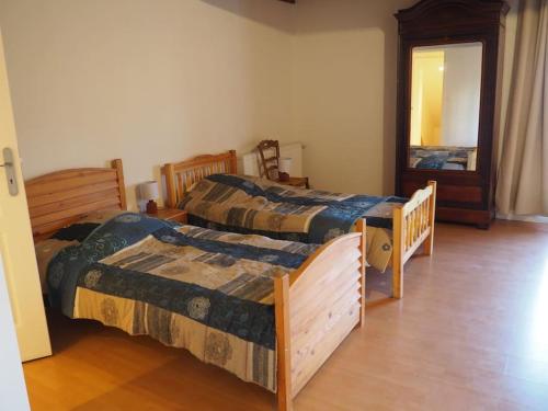 a bedroom with two beds and a mirror at La Crémaillère in Les Mazures