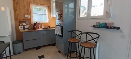 une cuisine avec deux tabourets de bar dans une cuisine dans l'établissement La Pivoine, à Trouville-sur-Mer