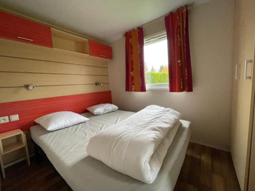 a bedroom with two beds in it with a window at Bungalow N52 - 6 personnes au calme - Camping Le Ried Boofzheim in Boofzheim