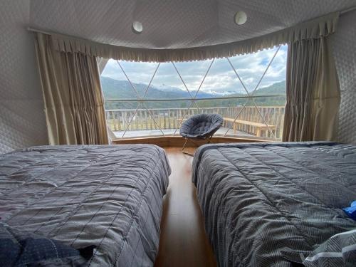 Puerto BertrandDomos Las Lengas Ch的一间卧室，配有两张床和一个大窗户