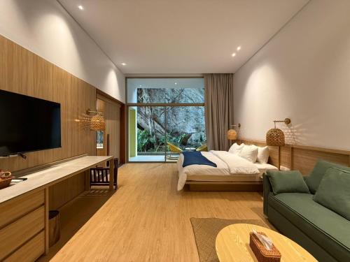 a living room with a bed and a large window at Ozone Cave in Thong Nai Pan Noi