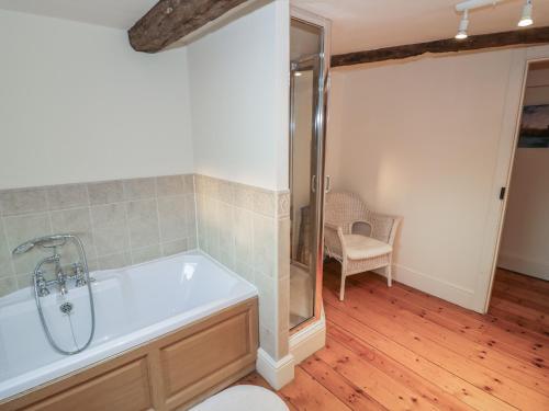 a bathroom with a shower and a bath tub at Dunnimere Farmhouse in Tamworth