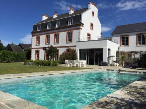 une grande maison avec une piscine devant dans l'établissement Un petit paradis insoupsonné, à Vannes
