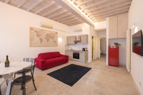 Una sala de estar con un sofá rojo y una cocina. en Villa Strozzi Travel Apartment, en Florencia