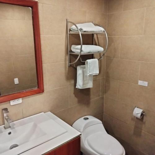 a bathroom with a sink and a toilet and a mirror at 593 Hotel Boutique Baños in Baños