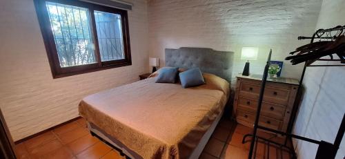 Un dormitorio con una cama y una cómoda y una ventana. en Oceanica la Paloma, en La Paloma