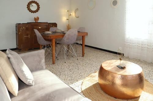 a living room with a table and a couch at Le Vallespir à 8 min à pied de la plage in Canet-en-Roussillon