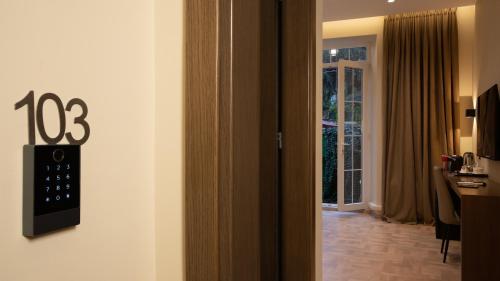 a room with a clock on the wall next to a door at CLOUD 5 Blloku Rooms Tirana in Tirana