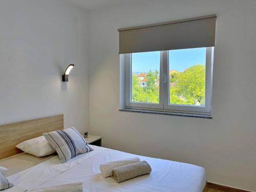a bedroom with two beds and a window at Apartments Bonum in Šilo
