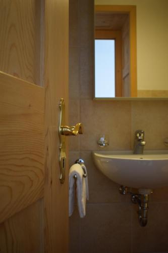 a bathroom with a white sink and a mirror at Hotel Bernina in Pontresina