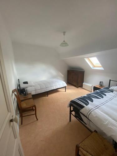 une chambre avec un lit et une chaise dedans dans l'établissement Maison de ville 13 couchages à 5 minutes du Pal, à Dompierre-sur-Besbre